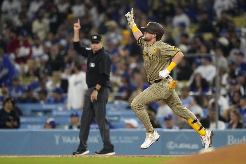 San Diego Padres' Jake Cronenworth, right, gestures as he round first after hitting a two-run home run during the first inning of a baseball game against the Los Angeles Dodgers, Tuesday, Sept. 24, 2024, in Los Angeles. (AP Photo/Mark J. Terrill)