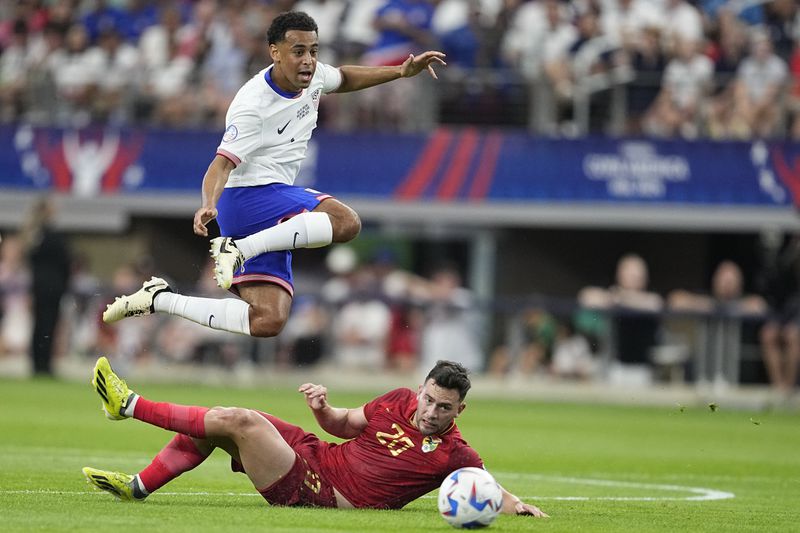 Tyler Adams of the United States jumps over Bolivia's Fernando Saucedo during a Copa America Group C soccer match in Arlington, Texas, Sunday, June 23, 2024. (AP Photo/Tony Gutierrez)