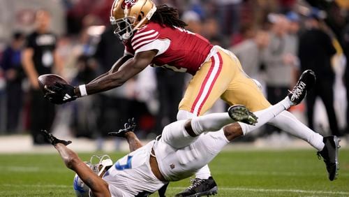 FILE - San Francisco 49ers wide receiver Brandon Aiyuk, top, catches a pass against Detroit Lions cornerback Kindle Vildor (29) during the second half of the NFC Championship NFL football game in Santa Clara, Calif., Sunday, Jan. 28, 2024. Brandon Aiyuk has requested a trade from the San Francisco 49ers because the two sides haven’t made progress on a new contract, a person familiar with the star wide receiver’s decision told The Associated Press on Tuesday, July 16.(AP Photo/Godofredo A. Vasquez, File)