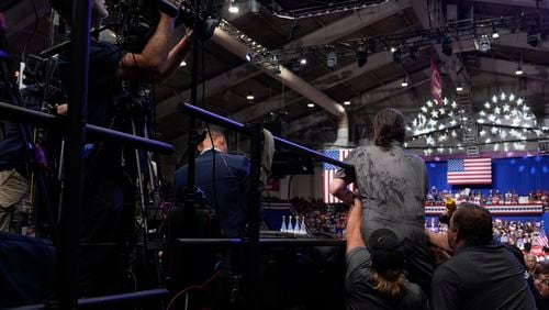 Police and security remove a man, right center, who had climbed over barricades and onto the media riser, as Republican presidential nominee former President Donald Trump speaks at a campaign event, Friday, Aug. 30, 2024, in Johnstown, Pa. (AP Photo/Alex Brandon)