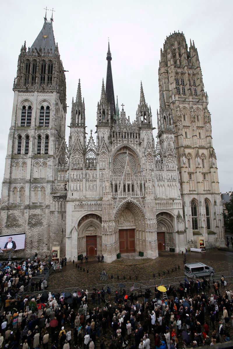 FILE - The crowd gather outside the Rouen cathedral, Normandy, during the funeral mass for Father Hamel, Tuesday, Aug.2, 2016. French authorities say a fire broke out Thursday JULY 11, 2024 on the spire of the medieval cathedral in the Normandy city of Rouen. (AP Photo/Michel Euler, File)