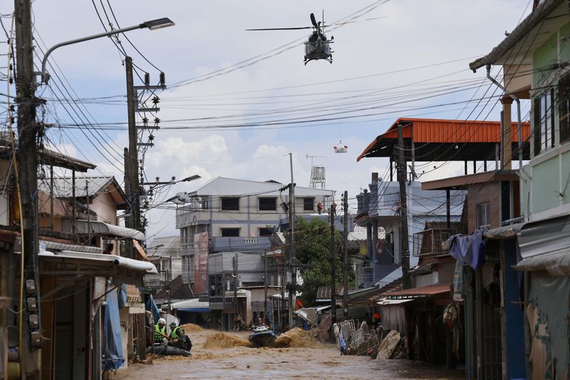 A Thai military helicopter drops relief supplies to flood victims and a rescue worker uses jet skis to search for victims in flooded areas in Chiang Rai Province, Thailand, Friday, Sept. 13, 2024. (AP Photo/Sarot Meksophawannakul)