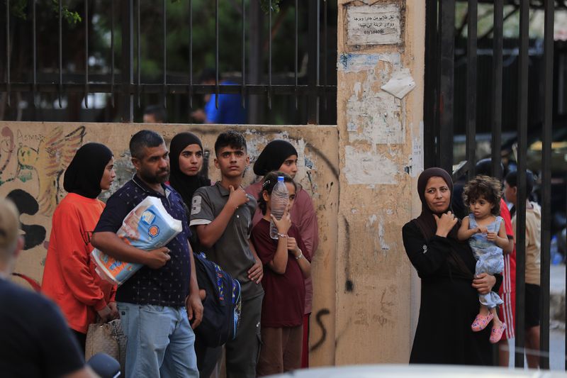 FILE - People fleeing the southern villages amid ongoing Israeli airstrikes, stand outside a school turned into a shelter in Sidon, Monday, Sept. 23, 2024. (AP Photo/Mohammed Zaatari, File)