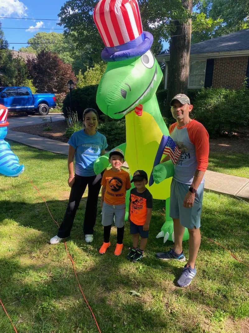 Lisa, Coby, Rex and Cesar Torres stand in front of one of their favorite dinosaurs in front of their Dunwoody Club Drive home. (Photo Courtesy of Cathy Cobbs)