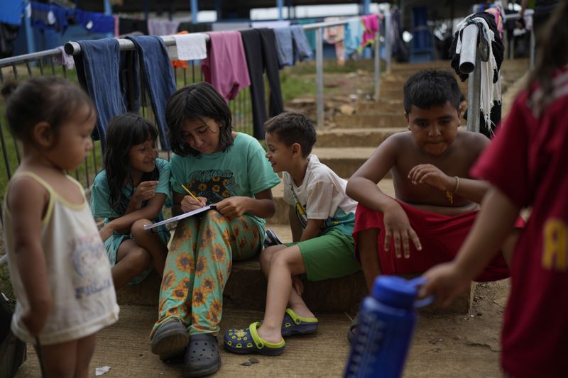 Children play at a camp for migrants in Lajas Blancas, Panama, after walking across the Darien Gap in hopes of reaching the U.S., Thursday, Sept. 26, 2024. (AP Photo/Matias Delacroix)