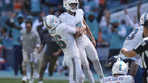 Miami Dolphins punter Jake Bailey (16) lifts place kicker Jason Sanders (7) after Sanders kicked the winning field goal during the second half of an NFL football game against the Jacksonville Jaguars, Sunday, Sept. 8, 2024, in Miami Gardens, Fla. The Dolphins defeated the Jaguars 20-17. (AP Photo/Wilfredo Lee)