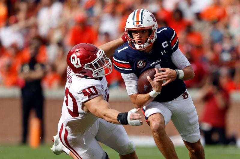 Auburn quarterback Payton Thorne (1) escapes the pressure of Oklahoma defensive lineman Ethan Downs (40) as he scrambles from the pocket during the first half of an NCAA college football game, Saturday, Sept. 28, 2024, in Auburn, Ala. (AP Photo/Butch Dill)