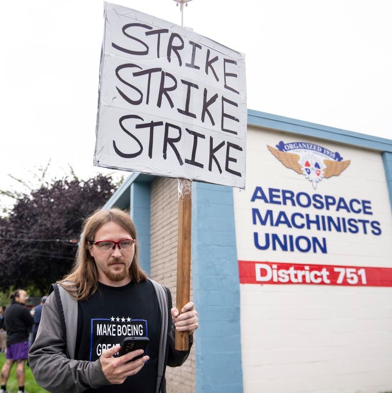 An International Aerospace Machinists union member holds a sign encouraging a strike as fellow union members negotiate a contract offer with airplane maker Boeing, on Thursday, Sept. 12, 2024, in Renton, Wash. (AP Photo/Stephen Brashear)