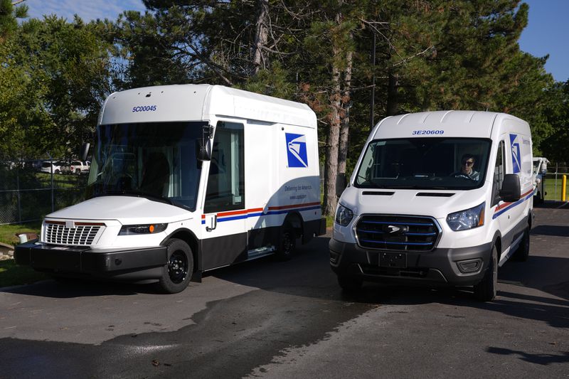 The U.S. Postal Service's next-generation delivery vehicle, left, is displayed as one new battery electric delivery trucks leaves the Kokomo Sorting and Delivery Center in Kokomo, Ind., Thursday, Aug. 29, 2024. (AP Photo/Michael Conroy)