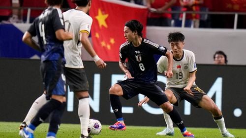 Japan's Takumi Minamino and China's Liu Yangyi compete for the ball during a World Cup and AFC Asian Qualifier between Japan and China at Saitama Stadium 2002 in Saitama, north of Tokyo, Thursday, Sept. 5, 2024.(AP Photo/Shuji Kajiyama)