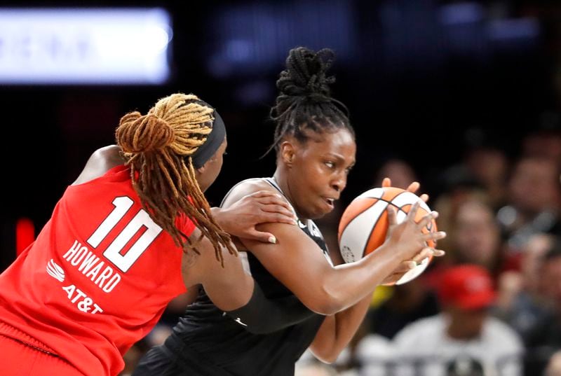 Las Vegas Aces guard Chelsea Gray (12) steals the ball from Atlanta Dream guard Rhyne Howard (10) during the first half of an WNBA basketball game Friday, Aug. 30, 2024, in Las Vegas. (Steve Marcus/Las Vegas Sun via AP)