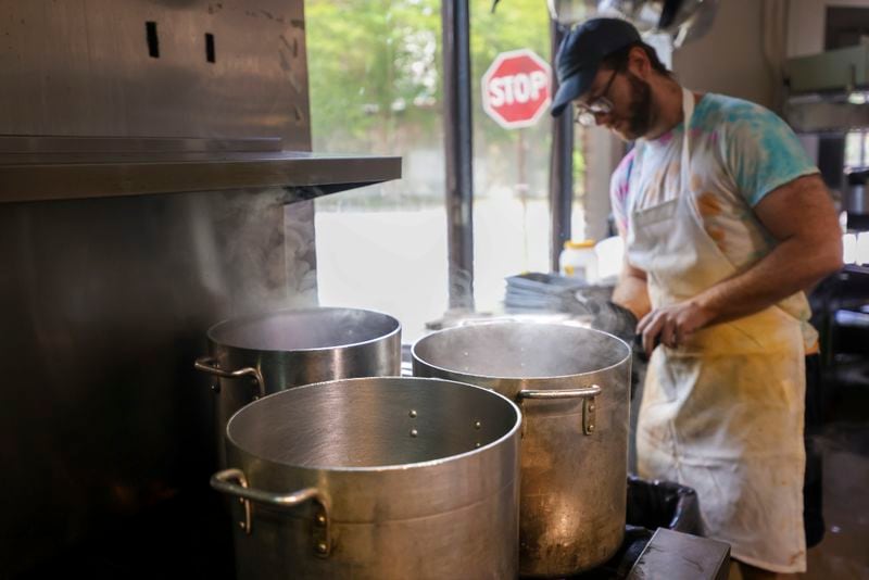 Line cook William Miracle works in the kitchen next to large pots that are boiling water at the restaurant, Sun in my Belly, in the Kirkwood neighborhood, Monday, June 3, 2024, in Atlanta. (Jason Getz / AJC)
