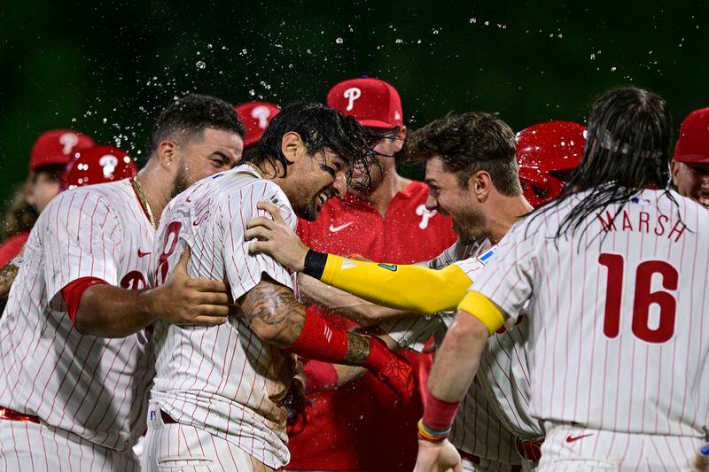 Philadelphia Phillies' Nick Castellanos, center left, celebrates with teammates after hitting a walk off single against Atlanta Braves' Grant Holmes during the 11th inning of a baseball game, Sunday, Sept. 1, 2024, in Philadelphia. (AP Photo/Derik Hamilton)