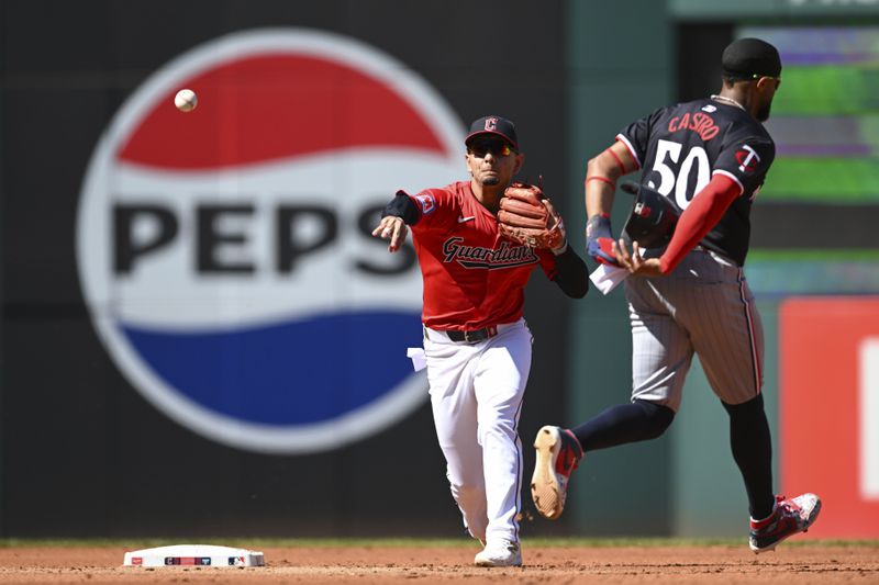 Cleveland Guardians' Andrés Giménez, left, throws out Minnesota Twins' Manuel Margot at first base after forcing out Willi Castro (50) at second base to complete a double play during the third inning of a baseball game, Thursday, Sept. 19, 2024, in Cleveland. (AP Photo/Nick Cammett)