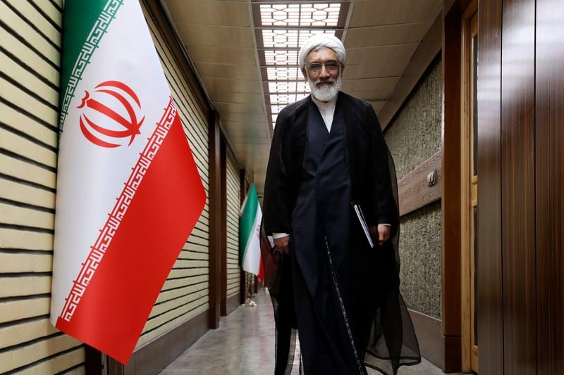 In this picture made available by Iranian state-run TV, IRIB, a presidential candidate for June 28, election Mostafa Pourmohammadi, a former Minister of Justice, arrives for a debate of the candidates at the TV studio in Tehran, Iran, Thursday, June 20, 2024. (Morteza Fakhri Nezhad/IRIB via AP)