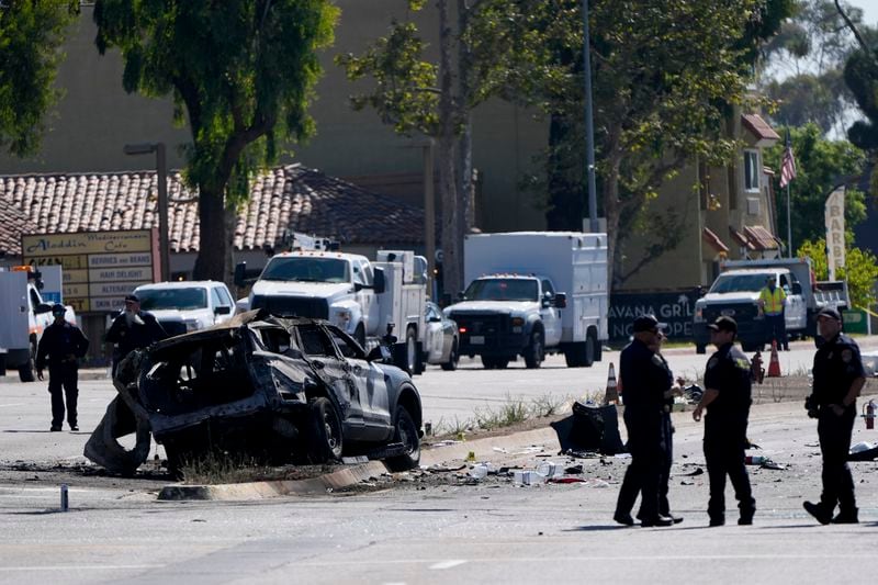 A charred police vehicle is seen in aftermath of an overnight crash which left an officer dead Tuesday, Aug. 27, 2024, in San Diego. (AP Photo/Gregory Bull)