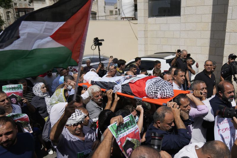 Mourners carry the body of Aysenur Ezgi Eygi, 26, who was fatally shot by Israeli soldiers while participating in an anti-settlement protest in the West Bank, during her funeral procession in the West Bank city of Nablus, Monday, Sept. 9, 2024. (AP Photo/Nasser Nasser)