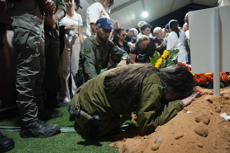 The sister of Petty Officer 1st Class David Moshe Ben Shitrit, who was killed on a Hezbollah attack, mourns during his funeral at the Mount Herzl military cemetery in Jerusalem, Sunday, Aug. 25, 2024. (AP Photo/Ohad Zwigenberg)