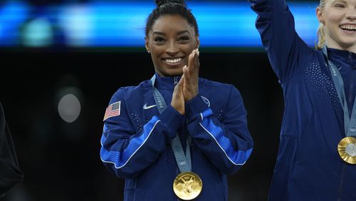 Simone Biles, of the United States, celebrates with teammates after winning the gold medal during the women's artistic gymnastics team finals round at Bercy Arena at the 2024 Summer Olympics, Tuesday, July 30, 2024, in Paris, France. (AP Photo/Charlie Riedel)