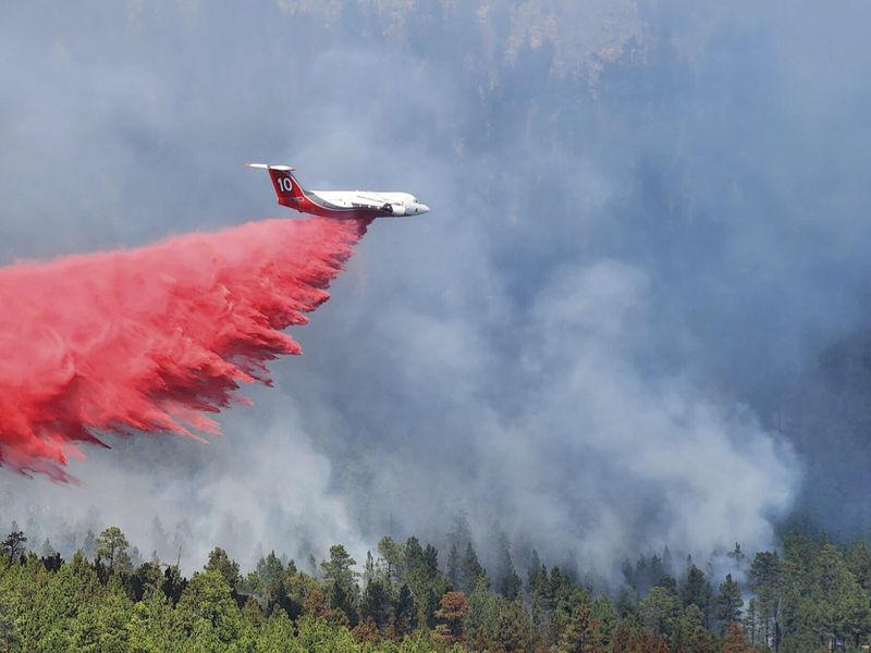 A heavy air tanker dumps fire retardant over the First Thunder Fire on Tuesday, Sept. 3, 2024 near Rapid City, S.D. (Madison Willis/Rapid City Journal via AP)