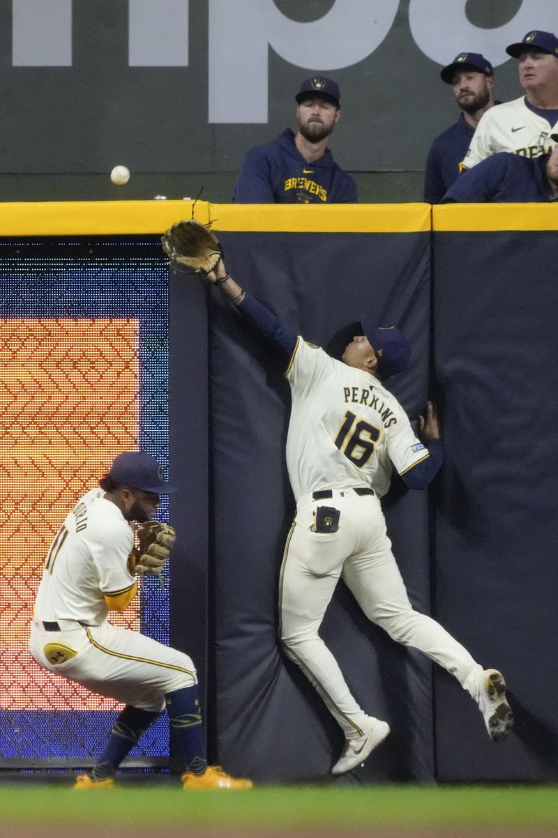 Milwaukee Brewers' Blake Perkins and Jackson Chourio can't catch a home run hit by Philadelphia Phillies' Brandon Marsh during the fifth inning of a baseball game Monday, Sept. 16, 2024, in Milwaukee. (AP Photo/Morry Gash)