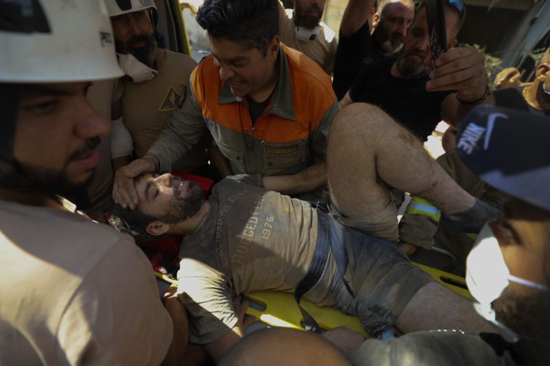 FILE - A survivor is taken out of the rubble after a massive explosion in Beirut, on Aug. 5, 2020. (AP Photo/Hassan Ammar, File)