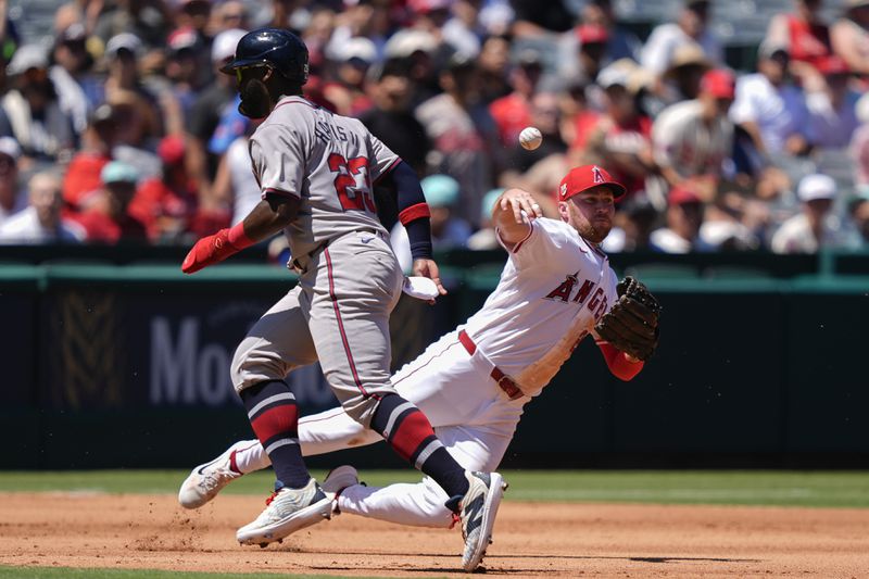 Los Angeles Angels third baseman Brandon Drury, right, throws out Atlanta Braves designated hitter Marcell Ozuna as Michael Harris II, left, attempts to reach third during the third inning of a baseball game, Sunday, Aug. 18, 2024, in Anaheim, Calif. (AP Photo/Ryan Sun)