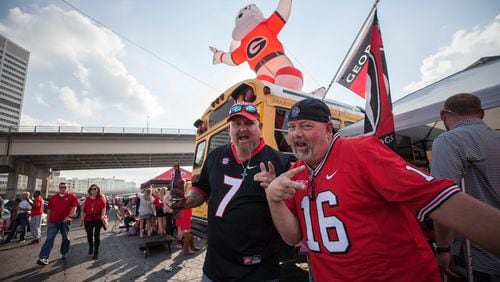 Georgia fans Buddy Robinson (left) and Chris Mileham tailgate before the SEC championship game between the Georgia Bulldogs and the Auburn Tigers, Saturday, Dec. 2, 2017, in Atlanta at Mercedes-Benz Stadium.