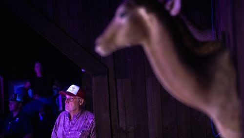 Jay Wallace, owner of gun store and indoor shooting range Adventure Outdoor in Smyrna, watches Tuesday's presidential debate during a Republican watch party at his store. (Arvin Temkar/AJC)