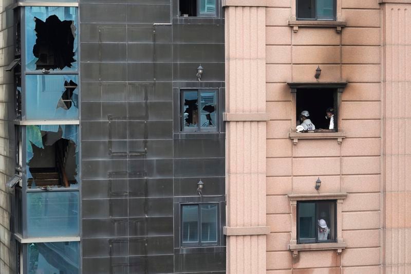 A joint investigation team examines the site of a hotel burnt by Thursday's fire in Bucheon, South Korea, Friday, Aug. 23, 2024. (AP Photo/Ahn Young-joon)