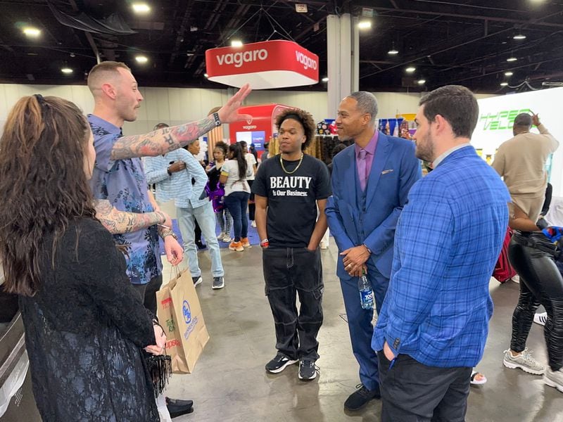 Bronner Bros. President James Bronner (2nd from right) and his son, John Bronner (center), chat with vendors at the 77th annual Bronner Bros. International Beauty Show at Georgia World Congress Center. Photo provided by Jerome Dorn/In Da House Media