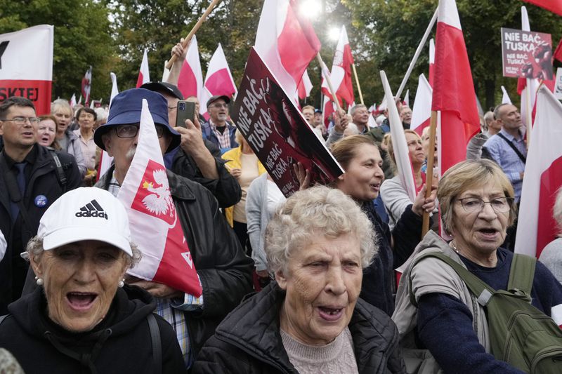 Backers of the right-wing opposition party Law and Justice take part in a protest ally of a few thousand people against the policies of Prime Minister Donald Tusk's Cabinet in Warsaw, Poland, Saturday Sept. 14, 2024. (AP Photo/Czarek Sokolowski)