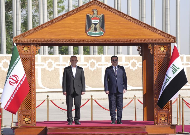 Iranian President Masoud Pezeshkian is welcomed by Iraqi Prime Minister Mohammed Shia al-Sudani, right, with an official ceremony at the Baghdad International Airport in Baghdad, Iraq, Wednesday Sept. 11, 2024. (Murtadha Al-Sudani/Pool Photo via AP)