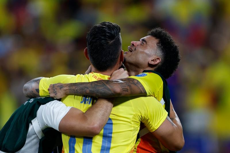 Colombia's Luis Diaz, right, and teammate James Rodriguez, center, celebrate their team's 1-0 victory over Uruguay at the end of a Copa America semifinal soccer match in Charlotte, N.C., Wednesday, July 10, 2024. (AP Photo/Nell Redmond)