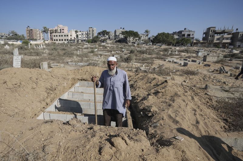 Palestinian grave digger Sa'di Baraka pauses while digging new graves in a cemetery in Deir al-Balah, Gaza Strip, Friday, Aug. 2, 2024, making room for more killed in the 10-month-old war. "We bury martyrs," Baraka said. "Sometimes we make graves on top of graves." (AP Photo/Abdel Kareem Hana)