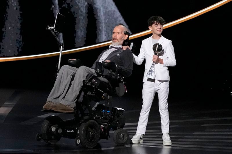 Steve Gleason, left, recieves the Arthur Ashe Award for Courage, held by his son Rivers, right, at the ESPY awards on Thursday, July 11, 2024, at the Dolby Theatre in Los Angeles. (AP Photo/Mark J. Terrill)