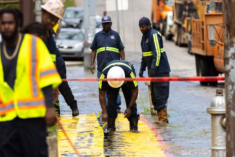 Workers take care of a water main break at Joseph E. Boone Boulevard and James P. Brawley Drive in Atlanta on Friday, May 31, 2024. (Arvin Temkar / AJC)