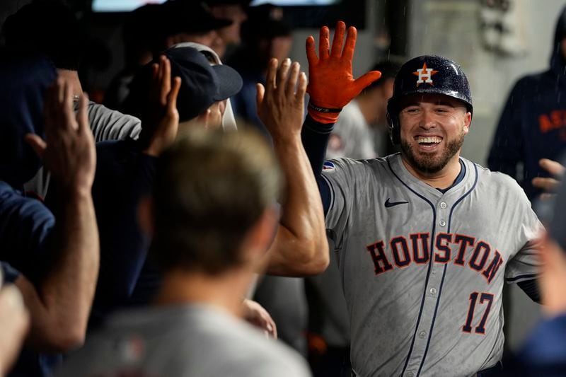 Houston Astros' Victor Caratini (17) is congratulated in the dugout after hitting a home run in the fifth inning of a baseball game against the Cleveland Guardians in Cleveland, Friday, Sept. 27, 2024. (AP Photo/Sue Ogrocki)