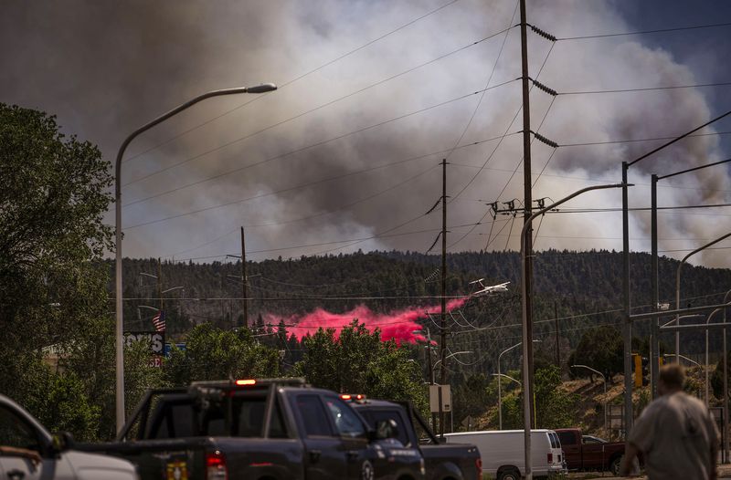 An air tanker drops fire retardant called slurry over and around wildfire-affected areas in the village of Ruidoso, N.M., Tuesday, June 18, 2024. (Chancey Bush/The Albuquerque Journal via AP)