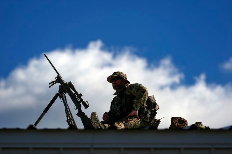 Law enforcement provides overwatch on a roof as supporters arrive before Republican presidential nominee former President Donald Trump speaks at a campaign rally at the Butler Farm Show, Saturday, Oct. 5, 2024, in Butler, Pa. (AP Photo/Julia Demaree Nikhinson)