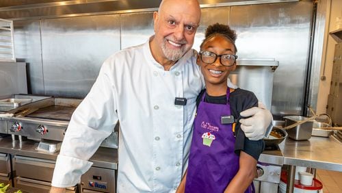 Chef Kameel Srouji and chef Yumara Nash cook salmon and pasta together in the Aviva by Kameel kitchen. Nash, 12, has built a following on social media for her cooking videos.