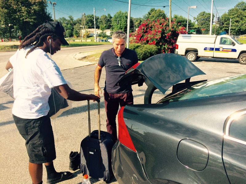 Oglethorpe president Lawrence Schall (right) drove Uber to experience another profession. Here, he completes the ride with passenger Mikael Pierre, a truck driver heading to a long haul. Fulton County will offer Uber rides to senior citizens. (BILL TORPY BTORPY@AJC.COM / AJC File Photo)