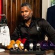 Tailor Carl Ulysses poses with items he designed for a portrait at The 500 Apartments in Atlanta on Friday, June 28, 2024. (Seeger Gray / AJC)