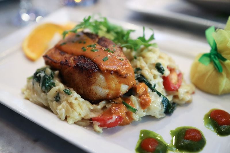 Chive's Chilean sea bass is drizzled with Asian-inspired red curry sauce and served on a bed of seasoned orzo. (Courtesy of Chive Sea Bar and Lounge)