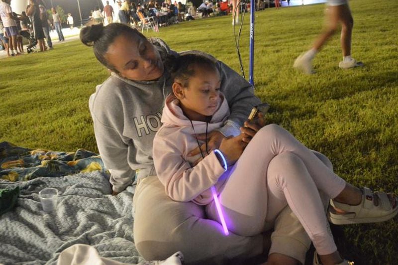 Serenity Medina and her daughter, Kali, relax on the main lawn at Suwanee's new Town Center on Main and DeLay Nature Park during the park's grand opening celebration on August 24, 2024. (Photo Courtesy of Curt Yeomans)