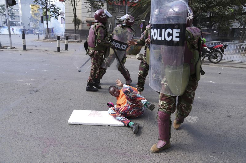 Kenya police beat a protester during a protest over proposed tax hikes in a finance bill in downtown Nairobi, Kenya Tuesday, June. 25, 2024. (AP Photo/Brian Inganga)