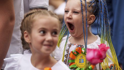 Children attend the traditional ceremony for the first day of school in Zaporizhzhia, Ukraine, Sunday Sept. 1, 2024. Zaporizhzhia schoolchildren celebrated the traditional first day of school near the frontline. With the front just 40 kilometers away, the war is never far from the minds of teachers and families. (AP Photo/Evgeniy Maloletka)