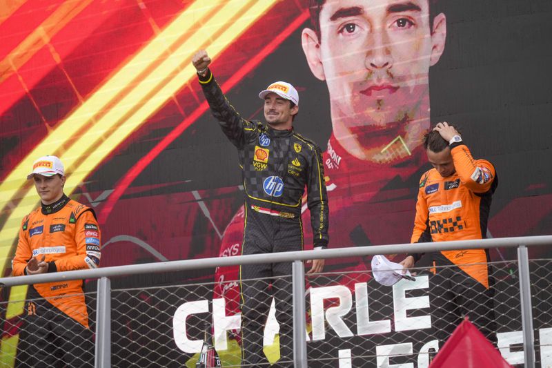 Ferrari driver Charles Leclerc of Monaco, centre, celebrates on the podium with second placed McLaren driver Oscar Piastri of Australia, left, and third McLaren driver Lando Norris of Britain after the Formula One Italian Grand Prix race at the Monza racetrack, in Monza, Italy, Sunday, Sept. 1, 2024. (AP Photo/Luca Bruno)