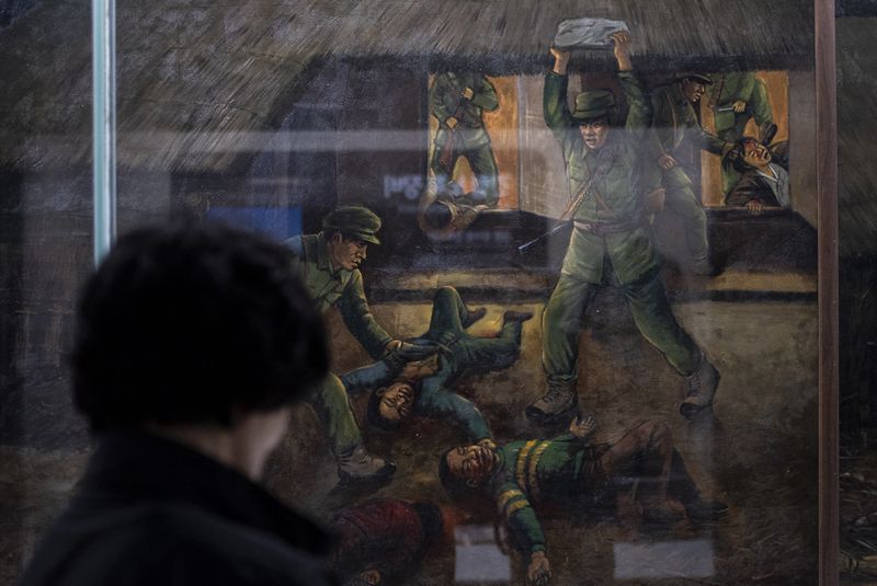 A visitor looks at a painting that depicts the murder of Lee Seung-bok and his family by North Korean infiltrators in 1968 at the Lee Seung-bok Memorial Hall in Pyeongchang, South Korea, Wednesday, May 22, 2024. (AP Photo/Jae C. Hong)