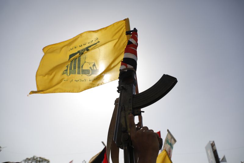 A Houthi supporter raises a Hezbollah flag during an anti-Israel and anti-U.S. rally in Sanaa, Yemen, Friday, Sept. 27, 2024. (AP Photo/Osamah Abdulrahman)